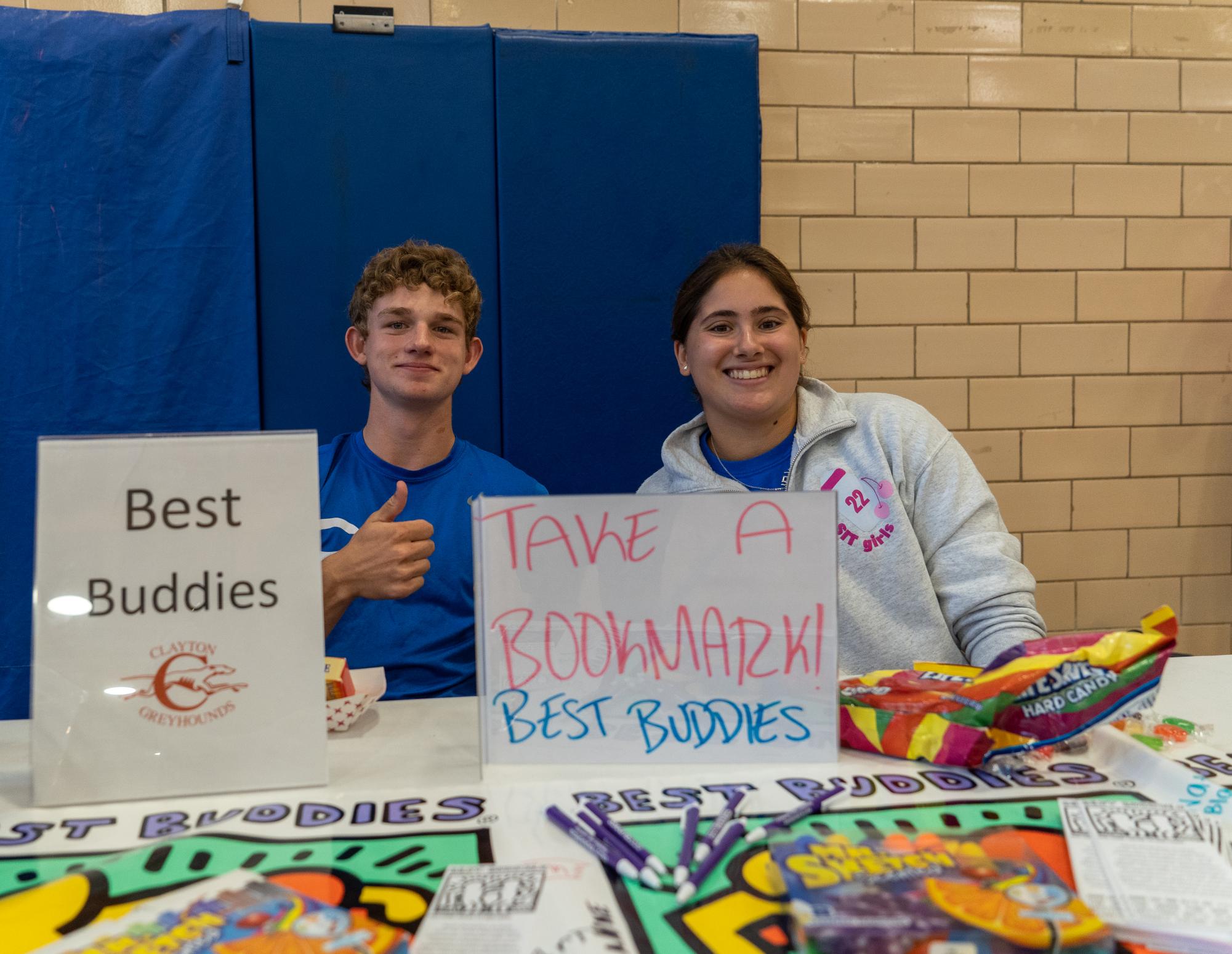 The club fair. Gathering in the gymnasium on August 25th, Best Buddies Club members advertised their organization to the greater student body. Seniors Luke Baker and Alex Cohen worked the table this year. Students mingled while leaders pitched their clubs.