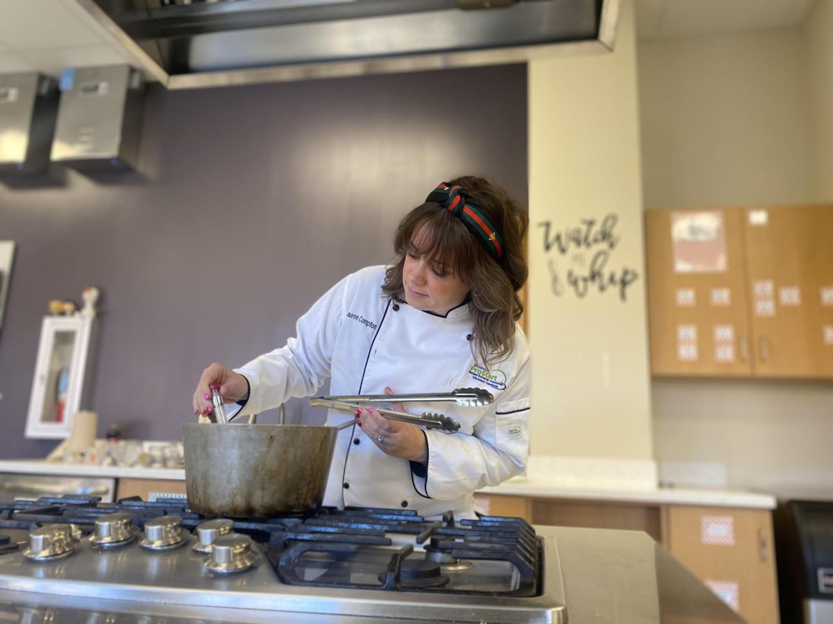 Demoing how to deep fry, Culinary Arts teacher Lauren Compton checks the oil temperature. 