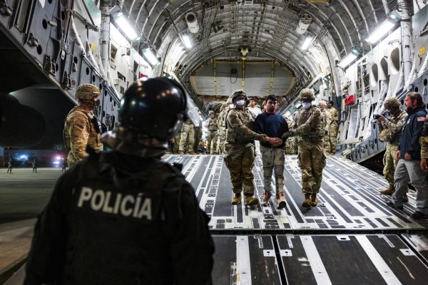 U.S. military personnel escort alleged members of the Venezuelan gang Tren de Aragua and the MS-13 gang recently deported by the U.S. government to be imprisoned in the Terrorism Confinement Center (CECOT) prison, at the El Salvador International Airport in San Luis Talpa, El Salvador April 12, 2025. Secretaria de Prensa de la Presidencia/Handout via REUTERS