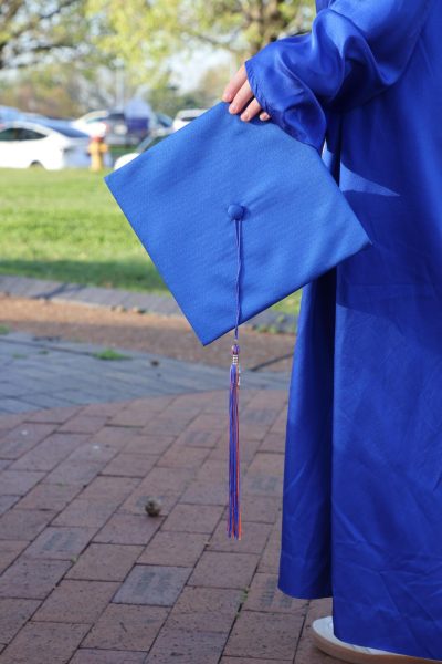 Senior Charlie Meyers holding a cap outside of school.