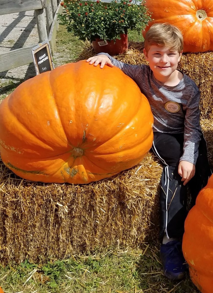 Elementary schooler Nate Linnenbringer poses with a giant pumpkin at Eckerts on a school field trip in 2018.