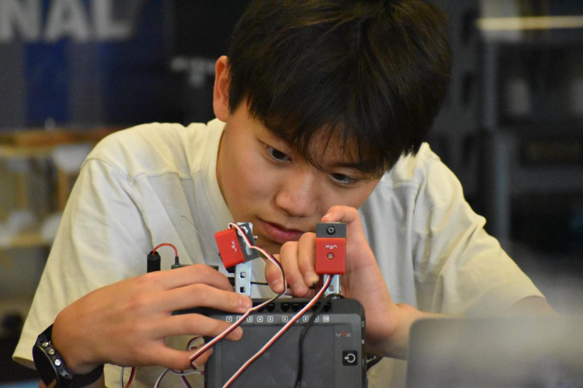 Freshman Marcus Zou builds a robot in his engineering class. Zou carefully attached wires to connect the robot’s motors to a brake. “I have learned so much about engineering and robotics, and it is really fun when my projects work how I want them to,” Zou said.