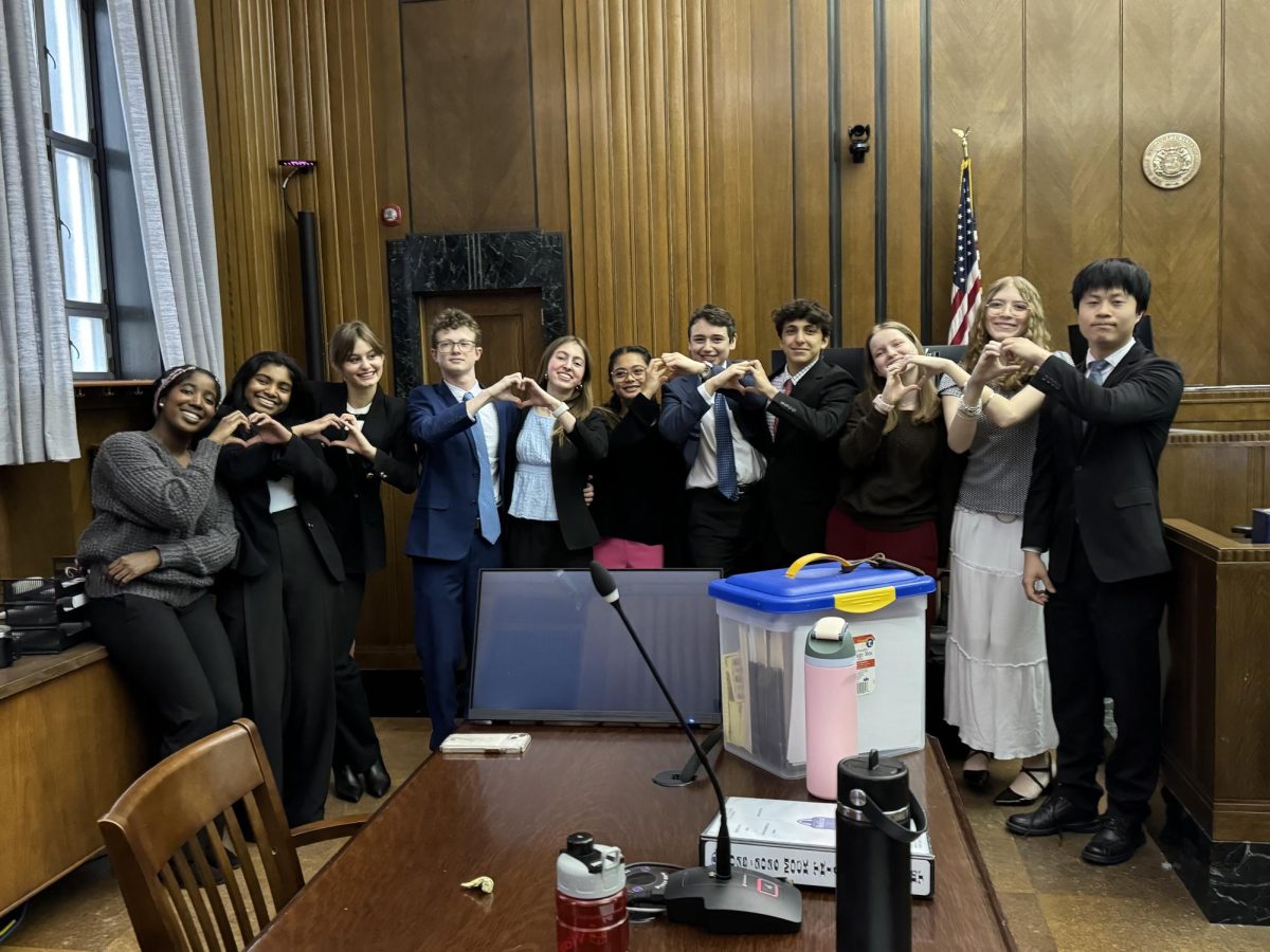The Mock Trial team poses for a photo in the courtroom where they competed in the semifinals round at the state tournament. 