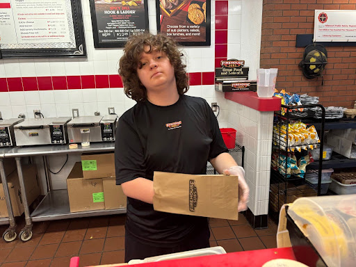Junior Connor Riley slides a turkey sandwich into a small bag in preparation to serve a customer. Riley has worked at Firehouse Subs for eight months. “What I enjoy most about Firehouse Subs is the opportunity to work with a team that cares about me,” Riley said. Photo by Jennifer Riley